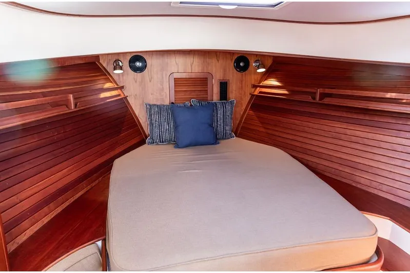 Pisces Yacht Photos Pics Cozy cabin interior of 2017 Hinckley Picnic Boat MKIII with wooden finish and cushions.