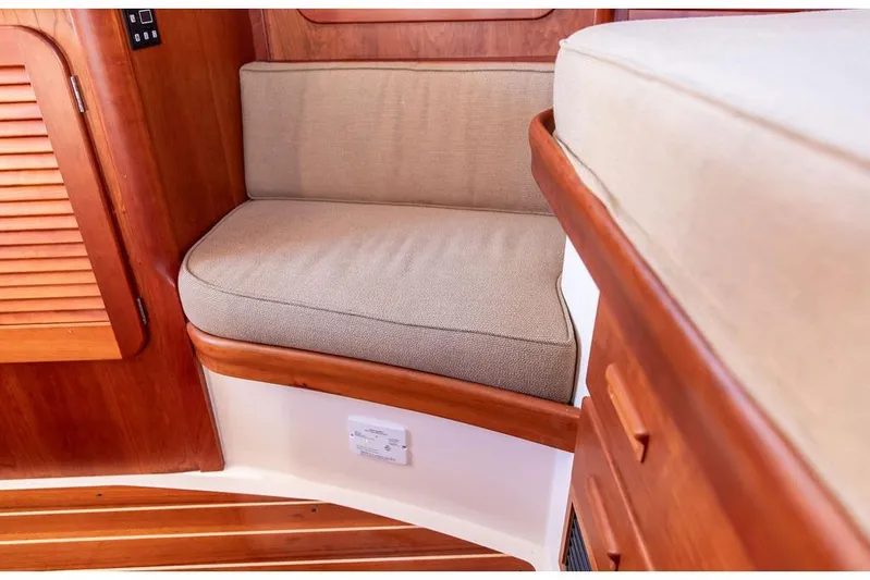 Pisces Yacht Photos Pics Interior seating of 2017 Hinckley Picnic Boat MKIII with wooden finish and beige cushions.