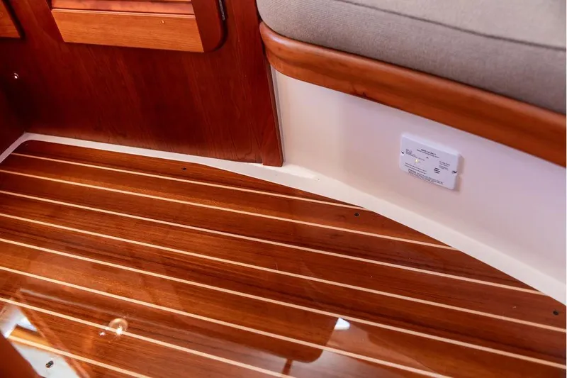 Pisces Yacht Photos Pics 2017 Hinckley Picnic Boat MKIII interior with polished wooden flooring and cushioned seating.