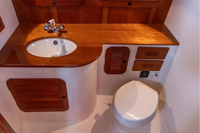Pisces Yacht Photos Pics 2017 Hinckley Picnic Boat MKIII bathroom with wooden cabinetry and modern fixtures.