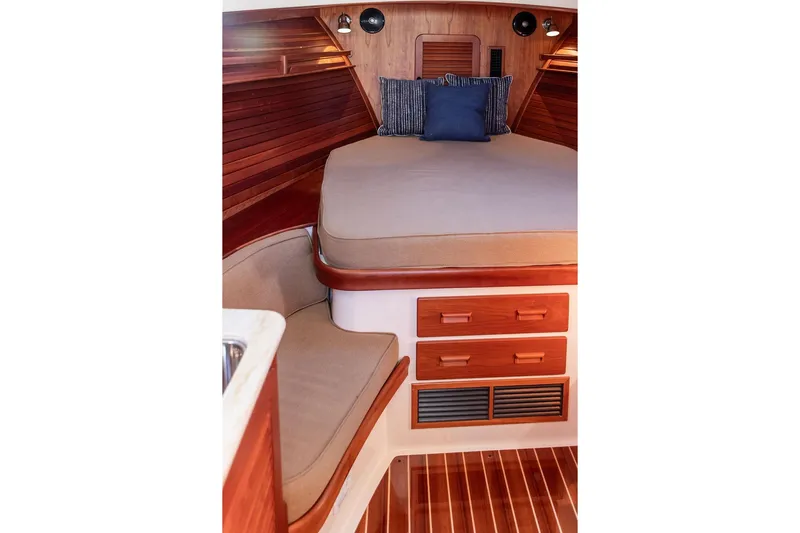 Pisces Yacht Photos Pics 2017 Hinckley Picnic Boat MKIII interior with wooden cabinetry and cozy sleeping area.