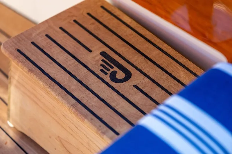 Pisces Yacht Photos Pics Wooden step with logo on 2017 Hinckley Picnic Boat MKIII, featuring striped fabric.