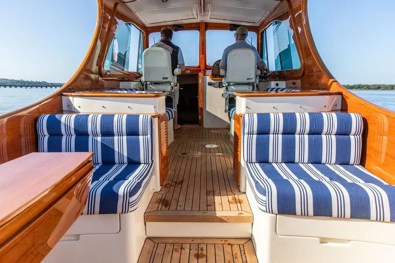 Pisces Yacht Photos Pics 2017 Hinckley Picnic Boat MKIII interior with striped seating and wooden finishes.