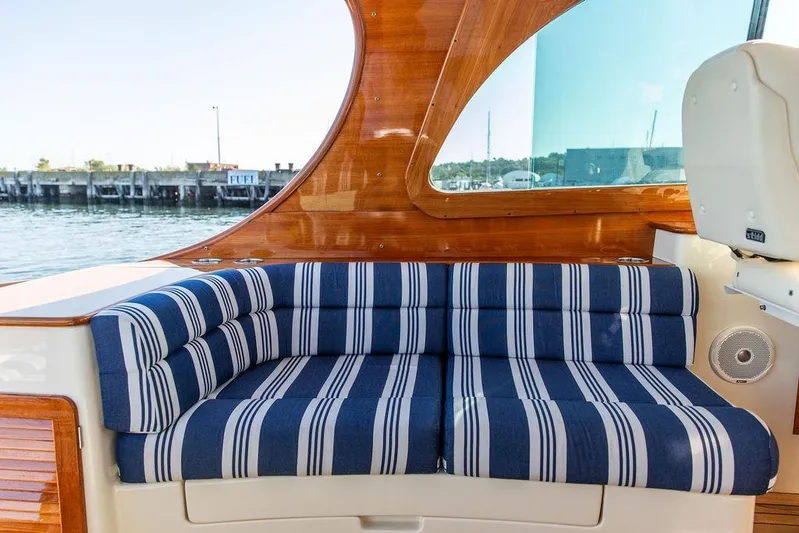 Pisces Yacht Photos Pics 2017 Hinckley Picnic Boat MKIII interior with striped seating and wooden accents.