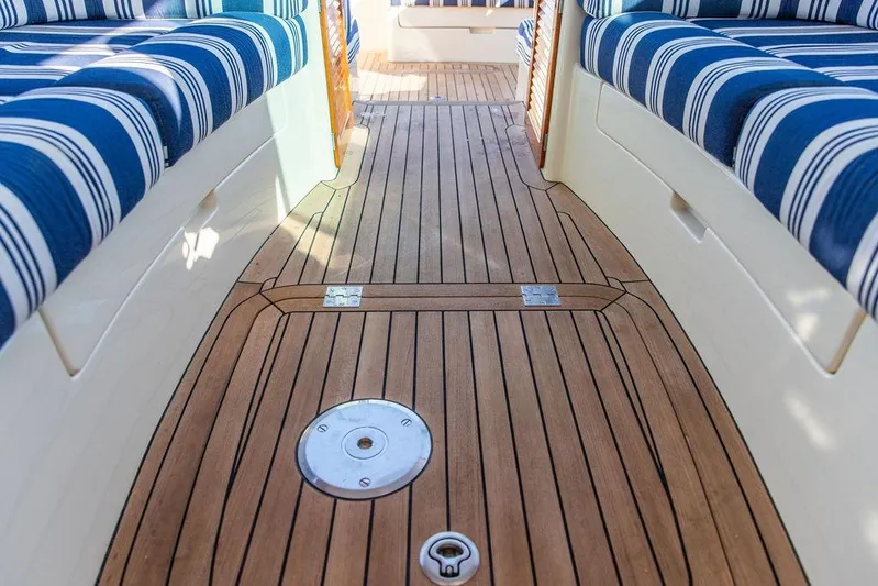 Pisces Yacht Photos Pics Interior of 2017 Hinckley Picnic Boat MKIII with striped seating and wooden flooring.