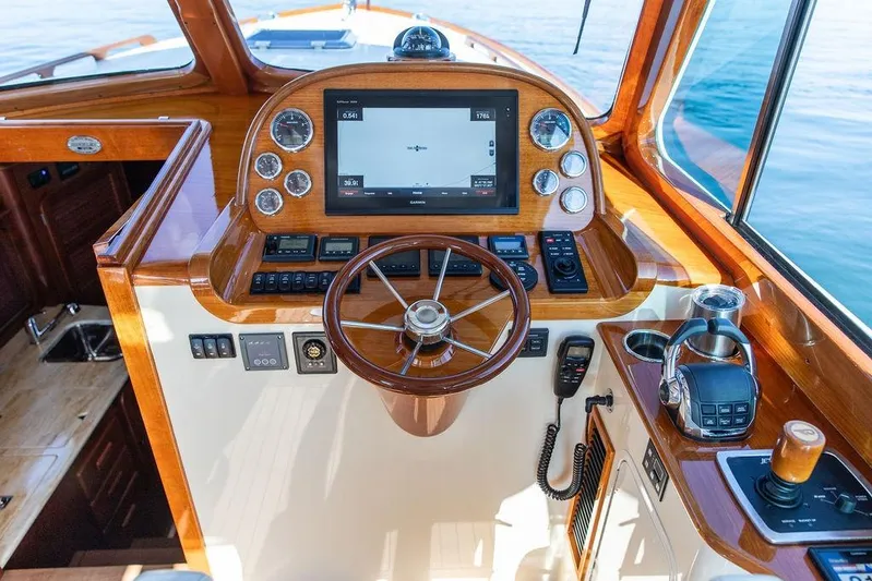 Pisces Yacht Photos Pics Hinckley Picnic Boat MKIII 2017 helm with wooden finish, modern controls, and navigation display.