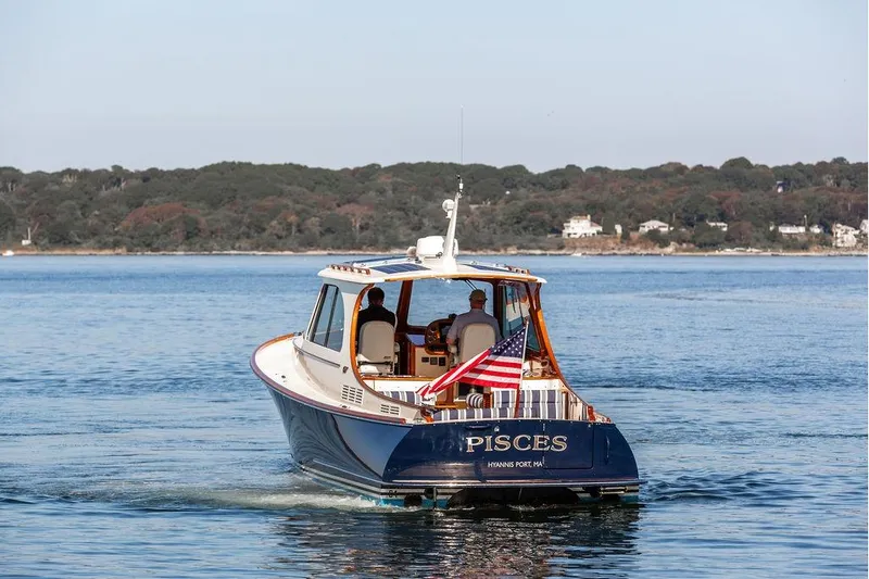 Pisces Yacht Photos Pics 2017 Hinckley Picnic Boat MKIII cruising on calm waters with American flag.