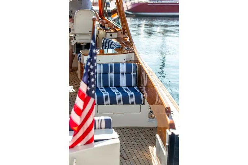 Pisces Yacht Photos Pics 2017 Hinckley Picnic Boat MKIII with striped seating and American flag on deck.