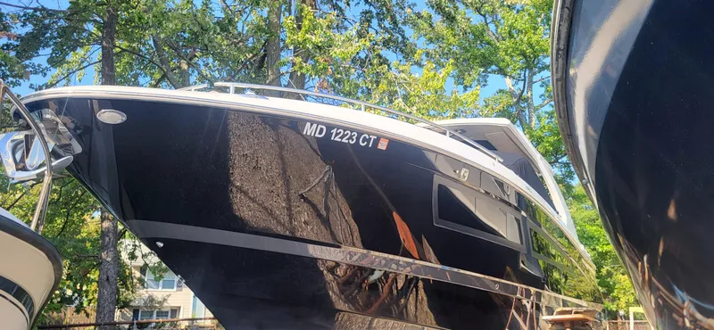  Yacht Photos Pics 2018 Four Winns H350 OB boat with sleek black hull, docked outdoors.