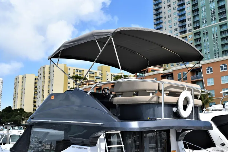  Yacht Photos Pics 2019 Silverton 41 Sport Bridge yacht docked in a marina with cityscape background.