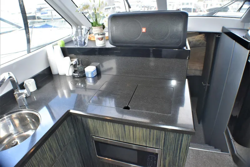  Yacht Photos Pics Modern kitchen area in 2019 Silverton 41 Sport Bridge yacht with sink, stove, and microwave.