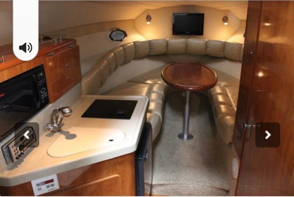 2007 Larson Cabrio 274 cabin interior with kitchenette, seating area, and TV.