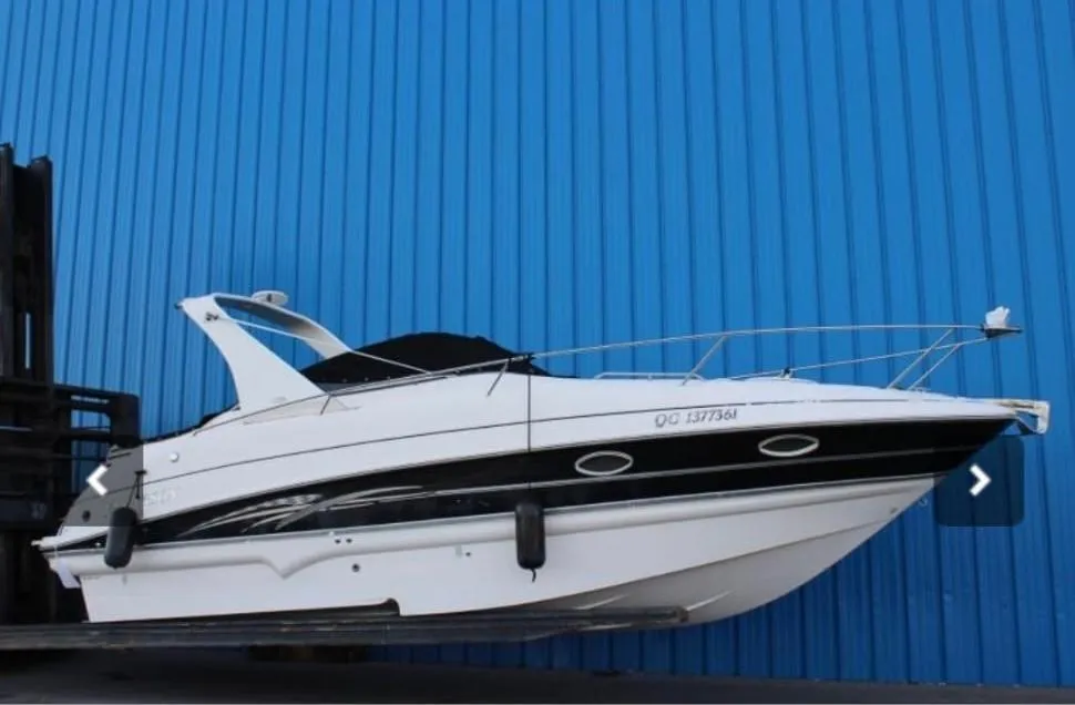 2007 Larson Cabrio 274 boat against a blue wall, side view.