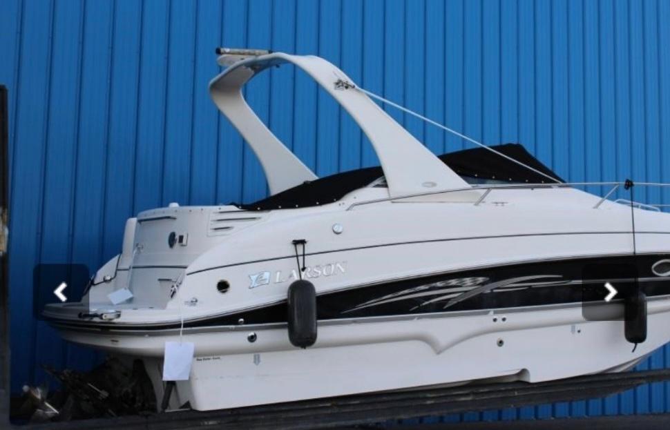 2007 Larson Cabrio 274 boat against a blue wall, side view.