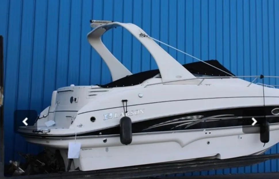 2007 Larson Cabrio 274 boat against a blue wall, side view.