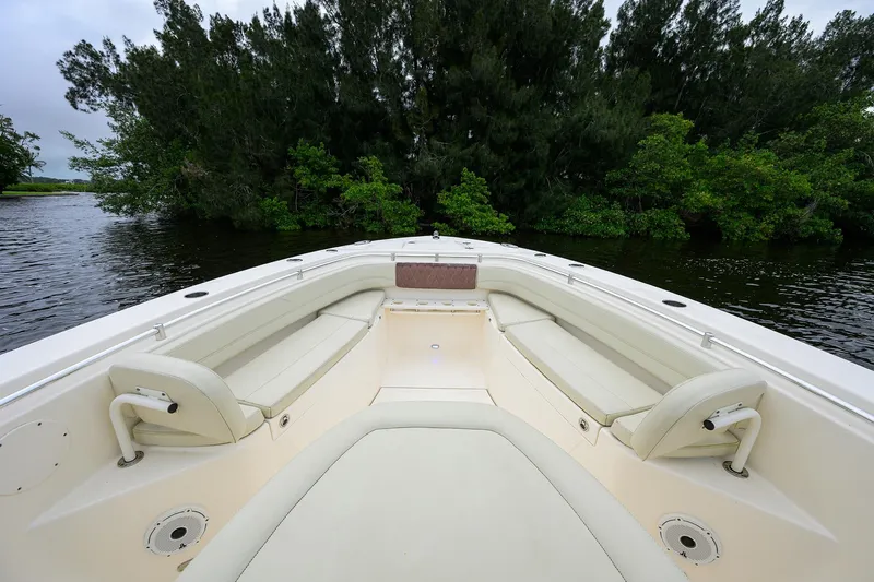 Conched Out Yacht Photos Pics 2020 Cobia 350 CC boat interior with seating, surrounded by lush greenery.