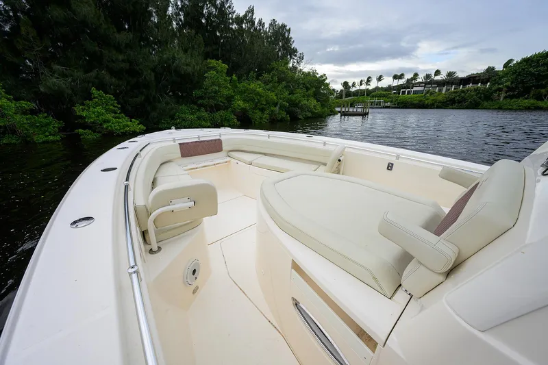 Conched Out Yacht Photos Pics 2020 Cobia 350 CC boat interior with seating, surrounded by lush greenery and calm waters.