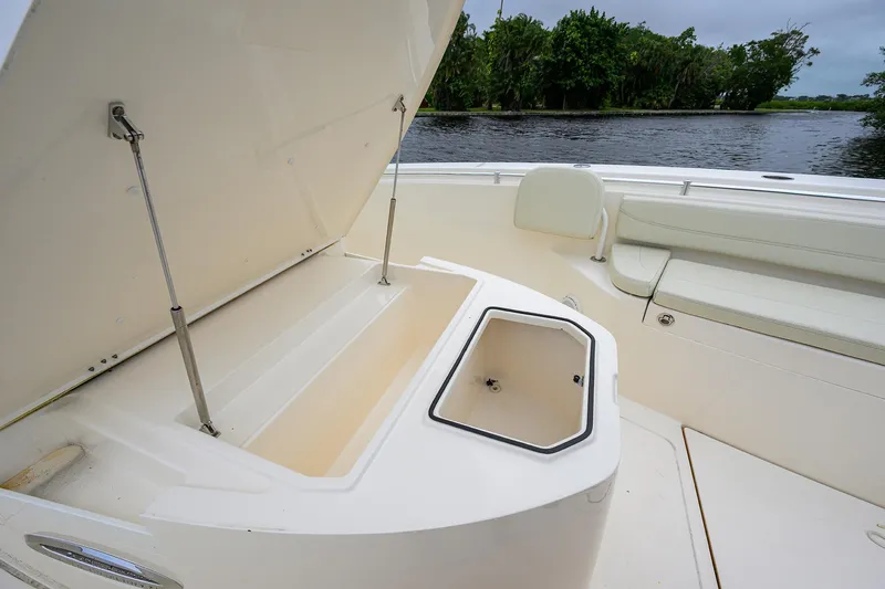 Conched Out Yacht Photos Pics 2020 Cobia 350 CC boat with open storage compartments, docked by a scenic river.