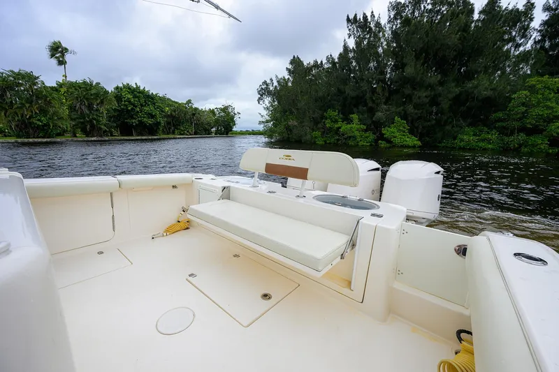 Conched Out Yacht Photos Pics 2020 Cobia 350 CC boat interior with seating, near lush green shoreline.