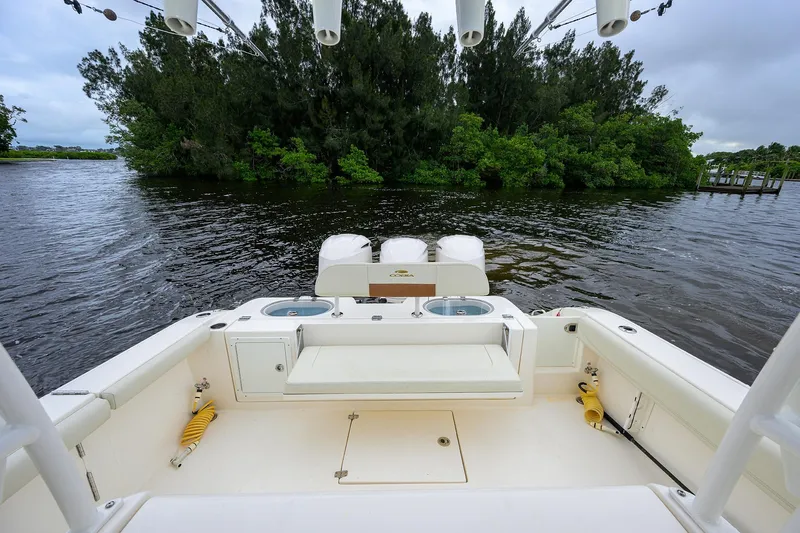 Conched Out Yacht Photos Pics 2020 Cobia 350 CC boat interior with fishing amenities, docked near lush greenery.