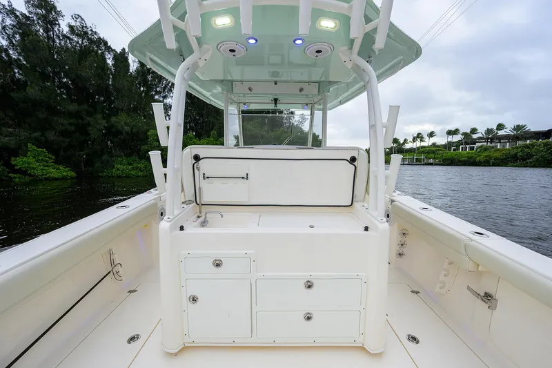 Conched Out Yacht Photos Pics 2020 Cobia 350 CC boat interior with storage compartments and canopy on a calm waterway.
