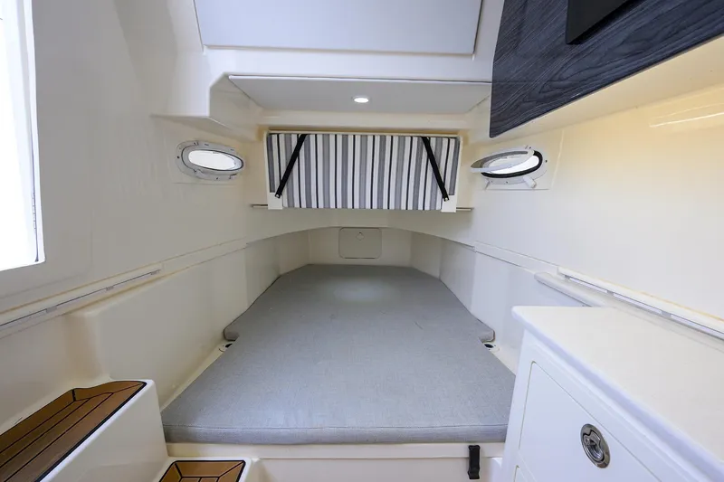 Conched Out Yacht Photos Pics 2020 Cobia 350 CC cabin interior with bed, portholes, and storage.