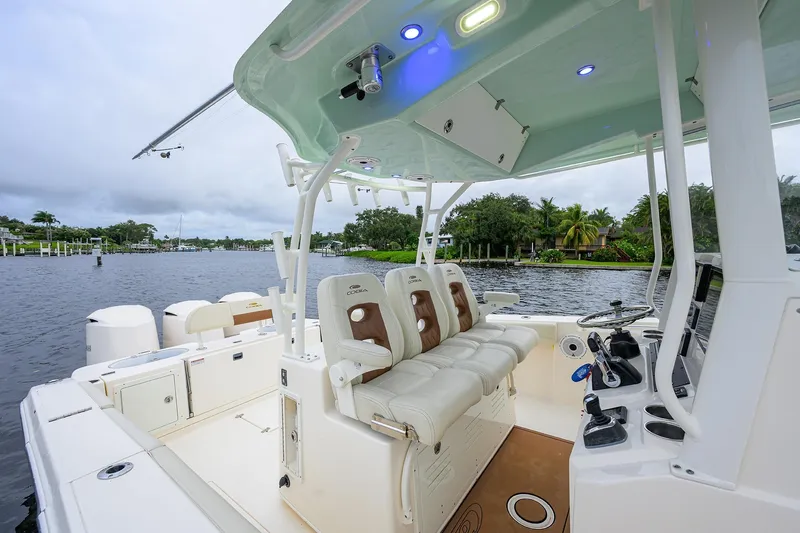 Conched Out Yacht Photos Pics 2020 Cobia 350 CC boat interior with seating and controls, docked on a scenic waterway.