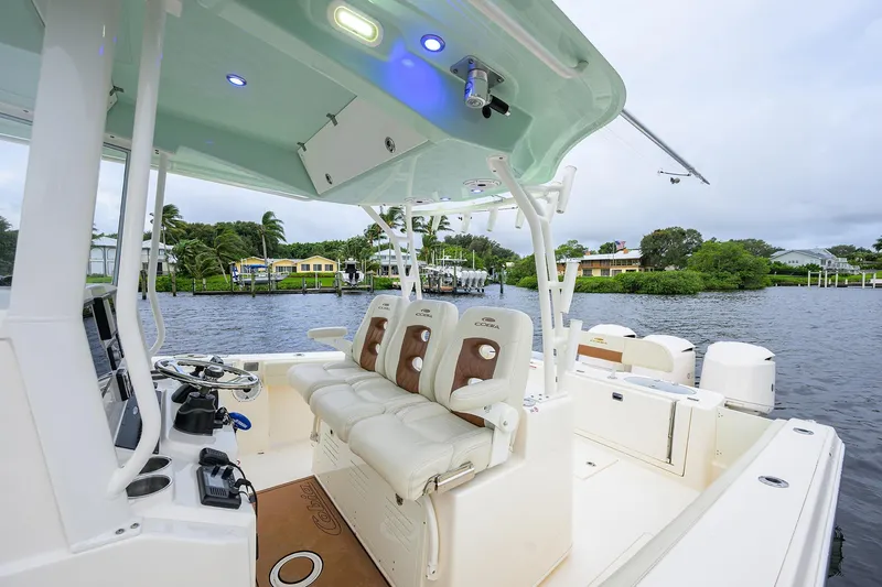 Conched Out Yacht Photos Pics 2020 Cobia 350 CC boat interior with seating and steering, docked by waterfront homes.