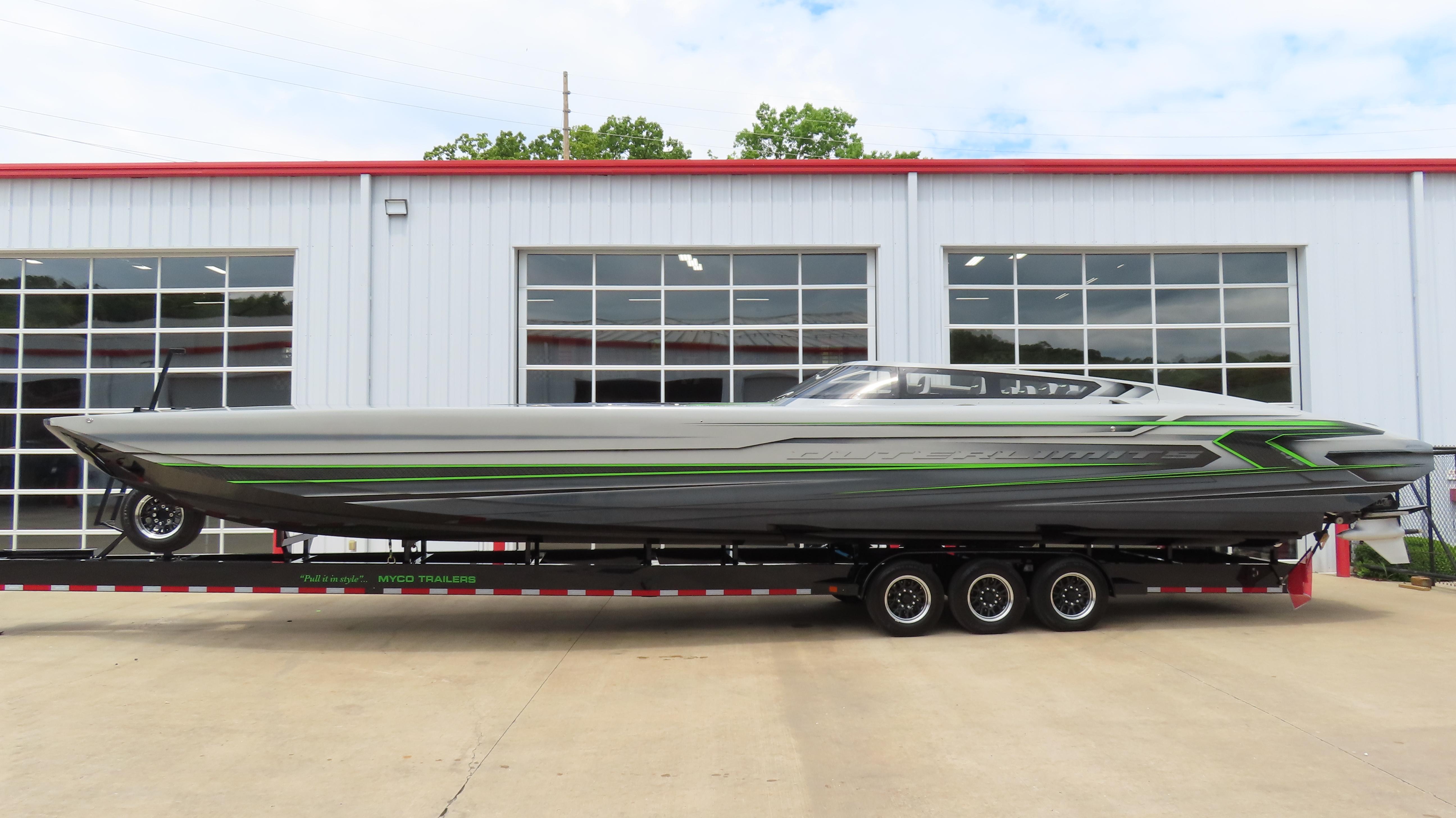 2025 Outerlimits 46 SC powerboat on trailer, parked outside a garage.