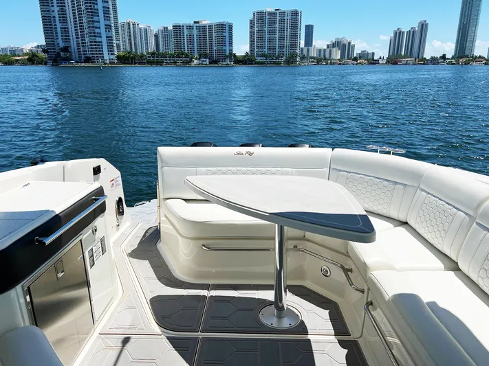 Grateful! Yacht Photos Pics 2019 Sea Ray Sundancer 320 Outboard interior with seating, table, and waterfront cityscape.