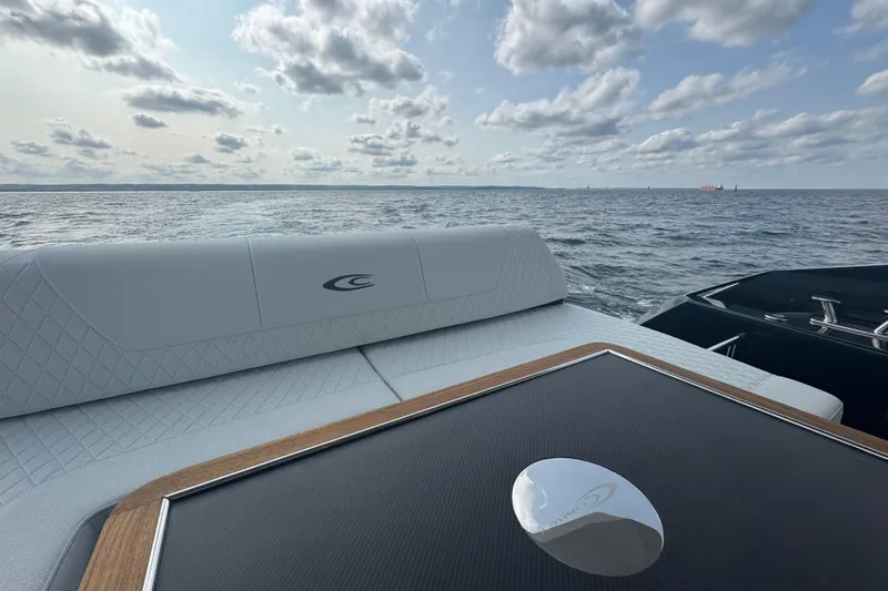 Custom Order Your 52 Fly Today! Yacht Photos Pics Luxurious 2026 Cobrey 52 FLY yacht with elegant seating, cruising on open water under a cloudy sky.