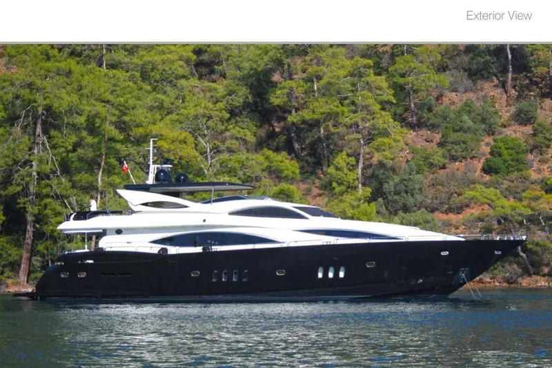 Natalia Yacht Photos Pics 2005 Sunseeker 105 Yacht on serene water, surrounded by lush greenery.