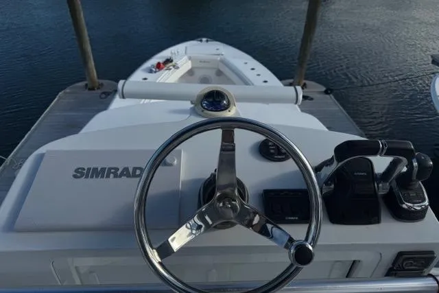  Yacht Photos Pics 2015 SeaHunter Center Console boat helm with Simrad navigation system, docked on calm water.