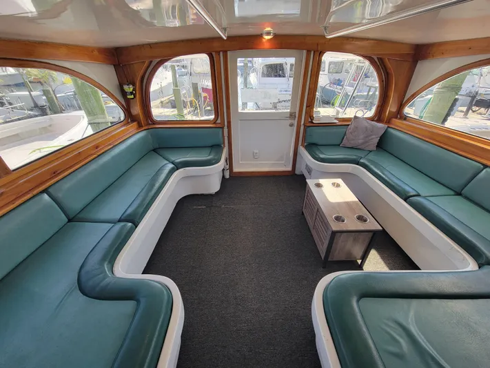  Yacht Photos Pics Luxurious interior of 1998 Custom Carolina 45 Willis Boatworks with green seating and wooden accents.