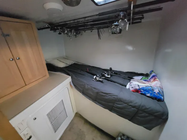  Yacht Photos Pics Interior cabin of 1998 Custom Carolina 45 Willis Boatworks with fishing rods and cozy bedding.