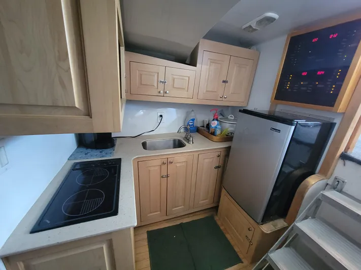  Yacht Photos Pics Compact kitchen in a 1998 Custom Carolina 45 Willis Boatworks, featuring wooden cabinets and modern appliances.