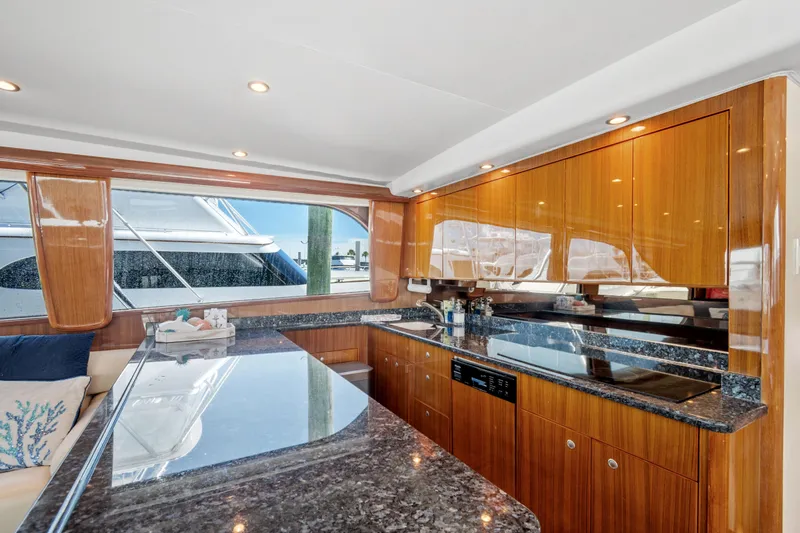 Sea Meant Yacht Photos Pics Luxurious kitchen interior of 2005 Viking 61 Convertible yacht with sleek wood cabinetry.