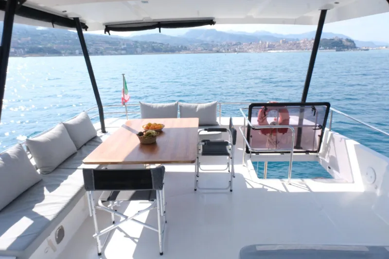  Yacht Photos Pics Luxurious 2020 Fountaine Pajot MY 44 yacht deck with seating and dining area, overlooking serene waters.