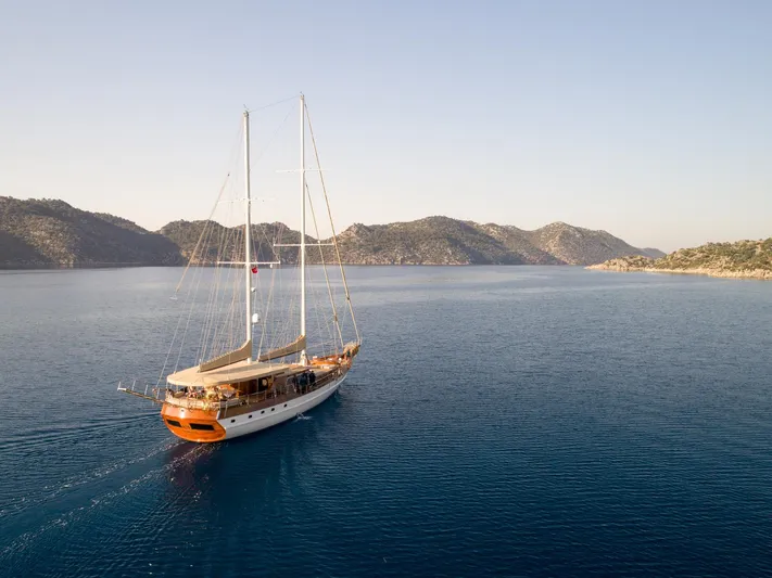  Yacht Photos Pics Custom 32 metre Gulet sailing on calm sea, 2007 model, with scenic mountainous backdrop.