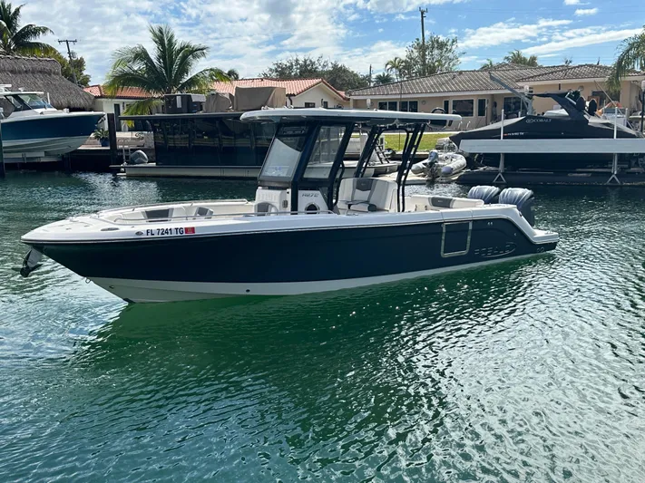  Yacht Photos Pics 2022 Robalo R272 boat docked in a sunny marina setting.