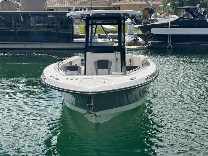  Yacht Photos Pics 2022 Robalo R272 boat docked on calm water, showcasing sleek design and modern features.