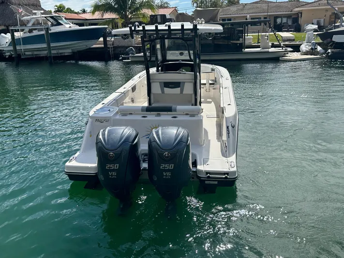  Yacht Photos Pics 2022 Robalo R272 boat with dual 250 V6 engines docked in a sunny marina.