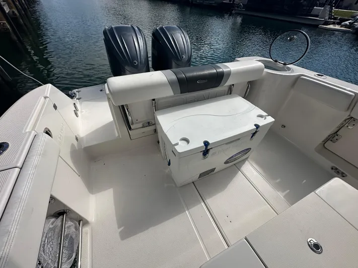  Yacht Photos Pics 2022 Robalo R272 boat deck with dual engines and cooler, docked by the water.