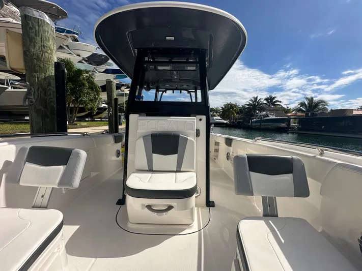  Yacht Photos Pics 2022 Robalo R272 boat interior with seating, docked near water under a clear sky.