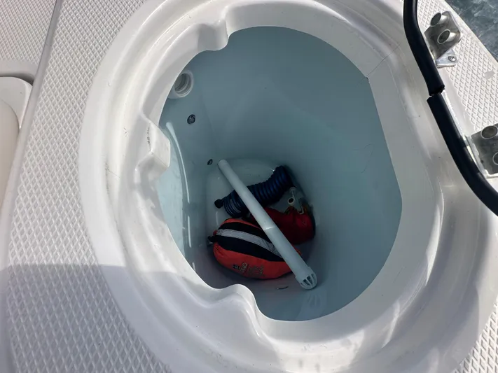  Yacht Photos Pics Storage compartment on a 2022 Robalo R272 boat with safety equipment inside.