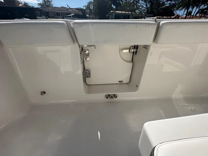  Yacht Photos Pics 2022 Robalo R272 boat interior with white seating and storage compartment.