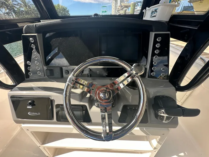  Yacht Photos Pics 2022 Robalo R272 boat dashboard with steering wheel and control panel.