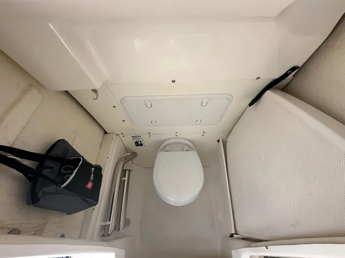  Yacht Photos Pics 2022 Robalo R272 boat interior with toilet and storage area.
