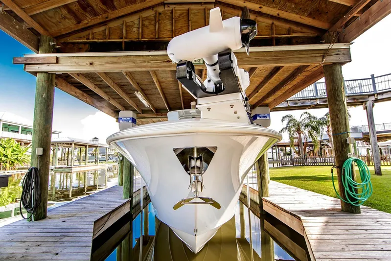  Yacht Photos Pics 2023 Front Runner 33 Center Console boat docked under wooden shelter.