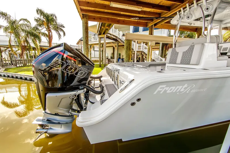  Yacht Photos Pics 2023 Front Runner 33 Center Console boat with powerful outboard engine, docked under a wooden canopy.